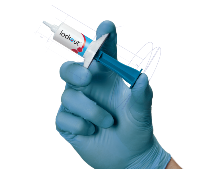 a gloved hand holding a syringe with Lockout written on the side